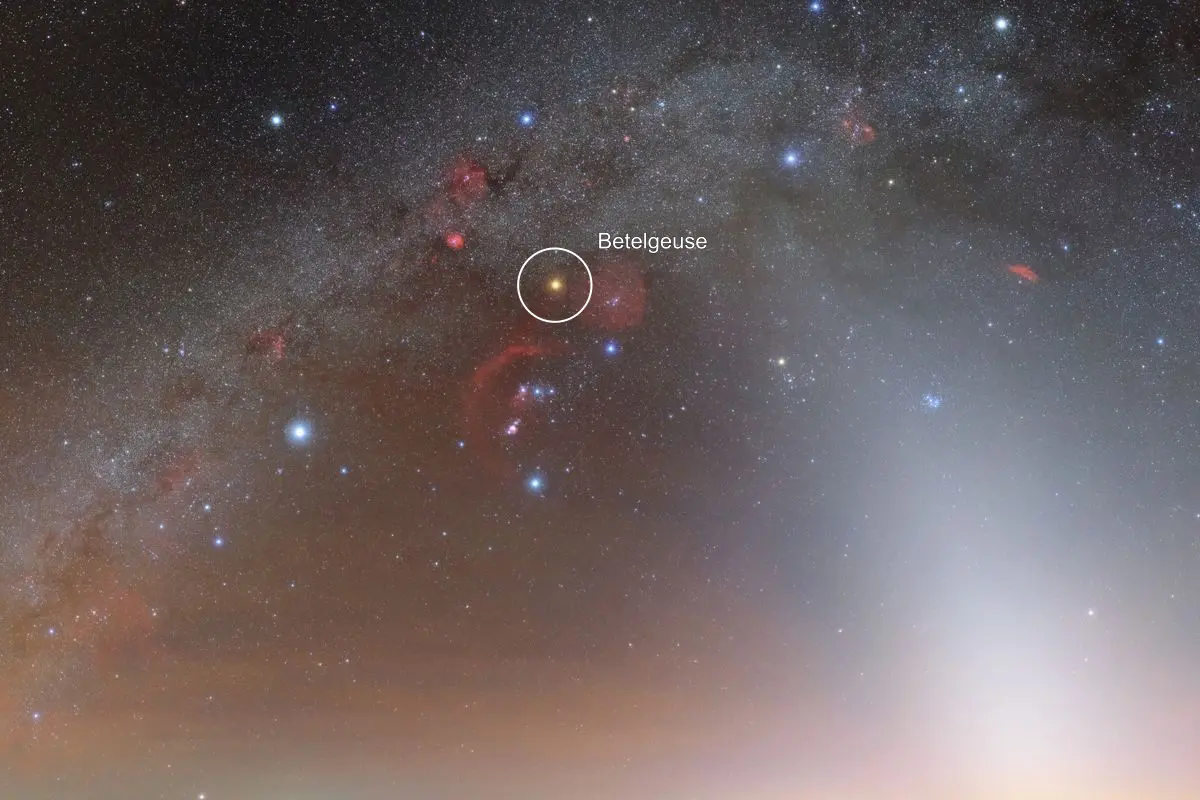 Night sky photo of the Milky Way and the constellation Orion with a white circle and label around the orange star Betelgeuse