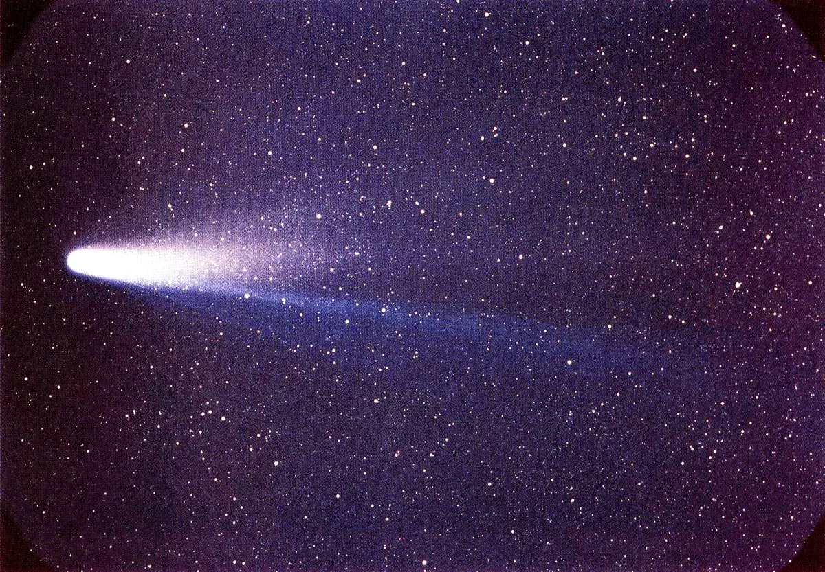 Halley's Comet in March 1986, a bright head with a long pale tail across a field of stars