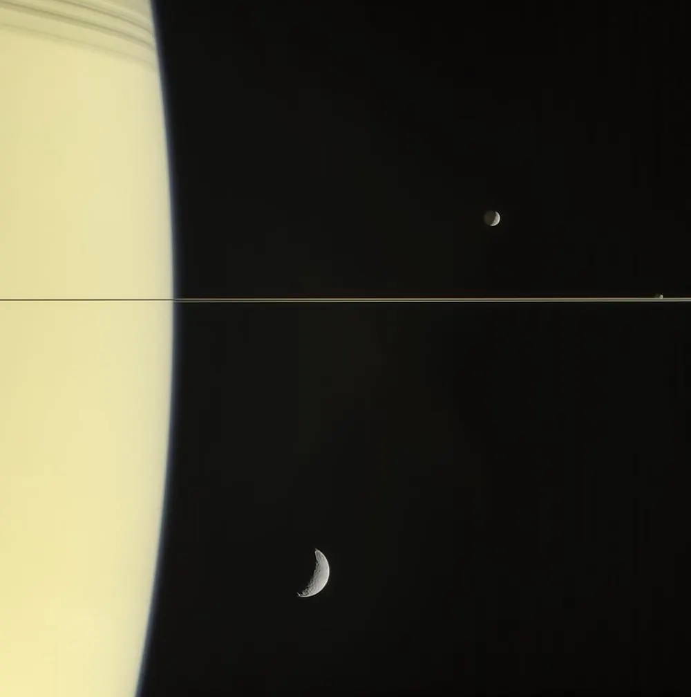 Saturn's rings seen nearly edge-on by Cassini as a single hair-thin line, with the small moons Mimas, Janus and Tethys nearby