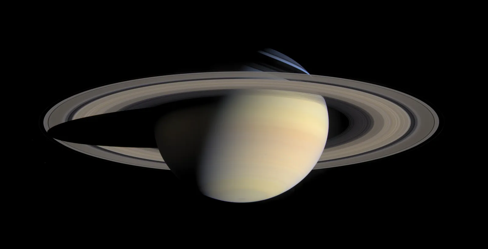 Saturn in natural color with its rings wide open, the planet's shadow falling across the rings on the left
